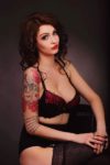 stripteaseuse avec tatouage sur le bras pose en lingerie noir dans la région centre